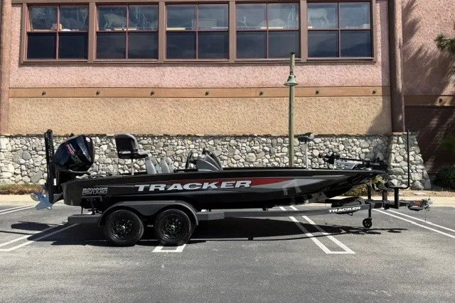 The Image of 2026 Tracker Savage 215 boat on trailer, parked in front of a stone wall building. - 0