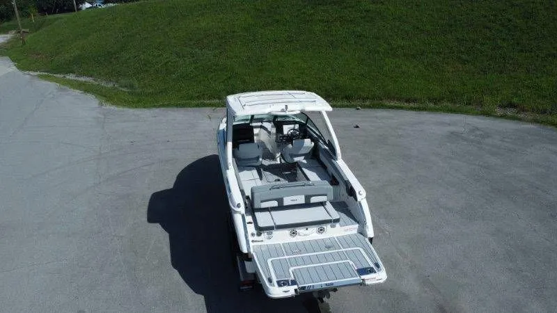 Slide: The Image of A 2026 Chaparral SSX 30 boat is parked on a paved area in front of a grassy hill. - 46