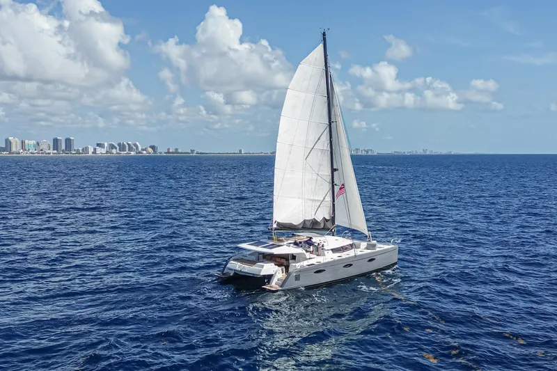 Slide: The Image of 2015 Fountaine Pajot Sanya 57 sailing near a coastal city under a clear blue sky. - 49