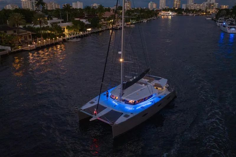Slide: The Image of Luxurious 2015 Fountaine Pajot Sanya 57 catamaran illuminated at night on a serene waterway. - 67