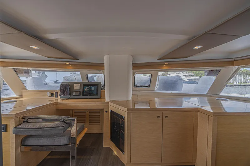 Slide: The Image of Interior of 2015 Fountaine Pajot Sanya 57 yacht, featuring modern navigation equipment and sleek wood finishes. - 13