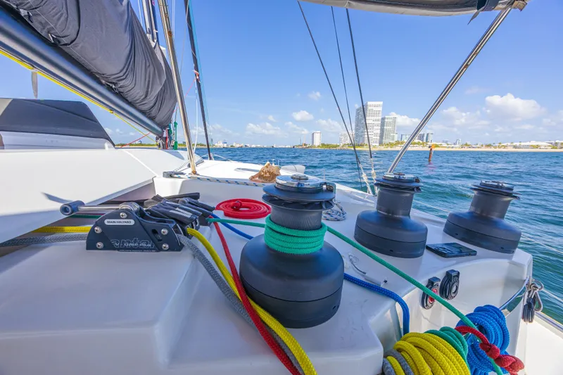 Slide: The Image of Deck view of 2015 Fountaine Pajot Sanya 57 catamaran with colorful ropes and city skyline. - 37