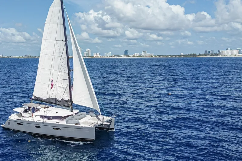Slide: The Image of Sailing catamaran Fountaine Pajot Sanya 57, 2015, cruising on blue ocean near city skyline. - 48