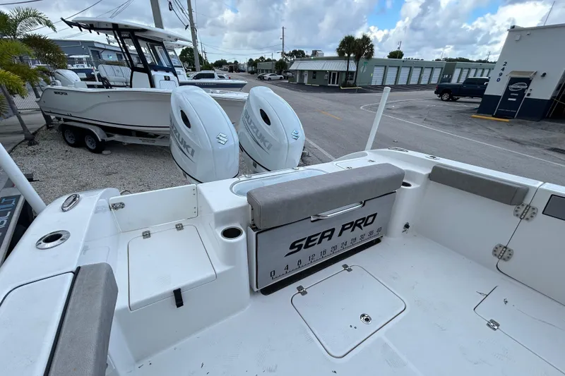 Slide: The Image of 2023 Sea Pro 259 Center Console boat with dual Suzuki engines, parked outdoors. - 18