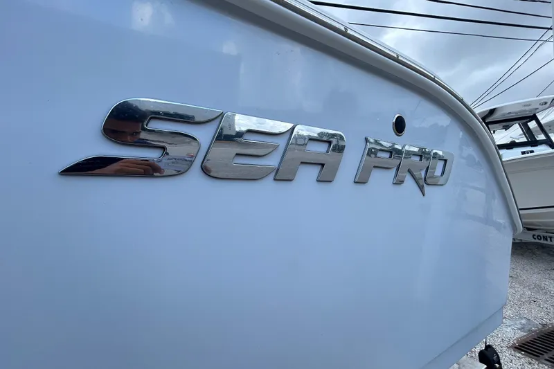 Slide: The Image of 2023 Sea Pro 259 Center Console boat with chrome logo detail. - 2