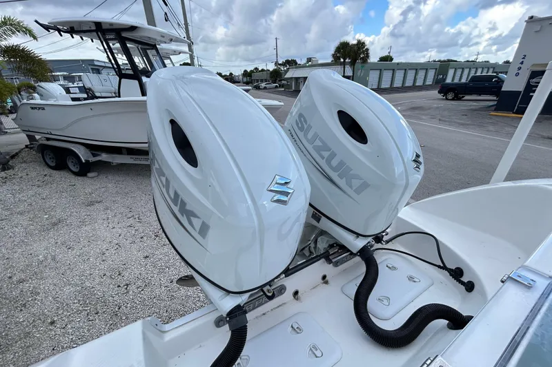 Slide: The Image of 2023 Sea Pro 259 Center Console with twin Suzuki outboard motors in a marina setting. - 21