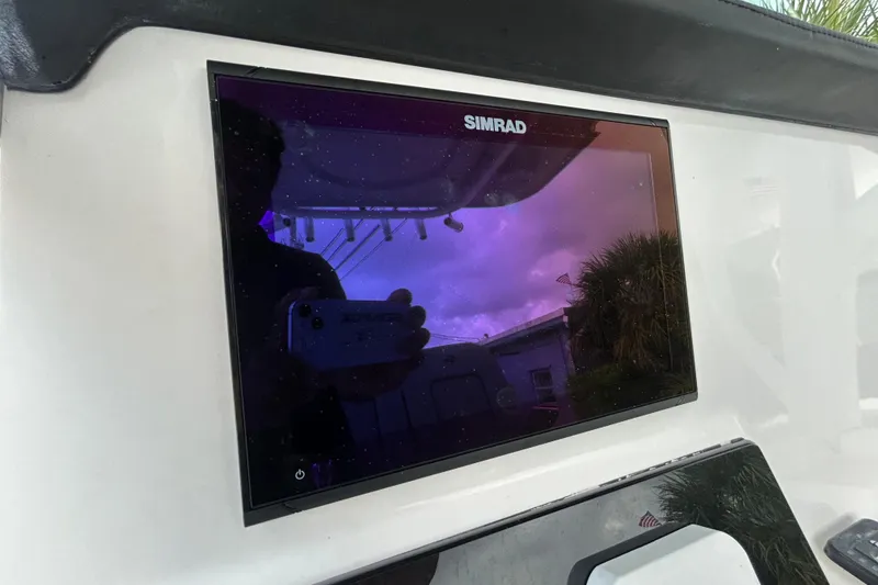 Slide: The Image of Simrad display on 2023 Sea Pro 259 Center Console boat, reflecting sky and surroundings. - 8