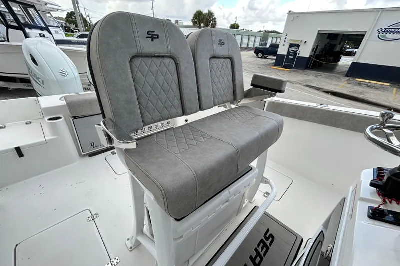 Slide: The Image of 2023 Sea Pro 259 Center Console boat with dual gray cushioned seats and steering wheel. - 17