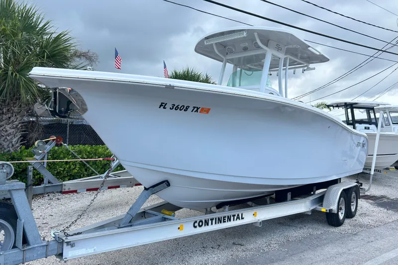The Image of 2023 Sea Pro 259 Center Console boat on trailer, parked outdoors. - 1