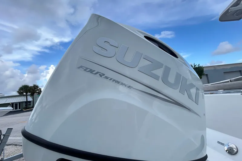 Slide: The Image of Suzuki four-stroke engine on 2023 Sea Pro 259 Center Console boat, under a blue sky. - 5
