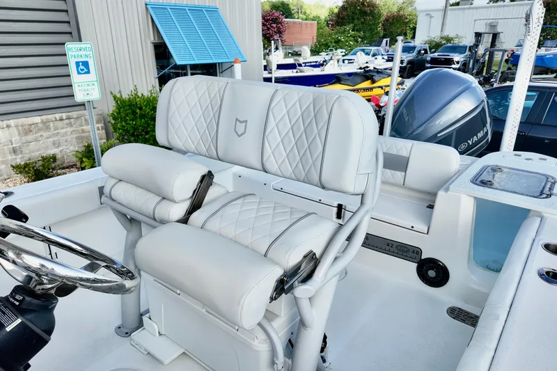 Slide: The Image of 2024 Sea Fox 248 Commander boat interior with white cushioned seating and steering wheel. - 8