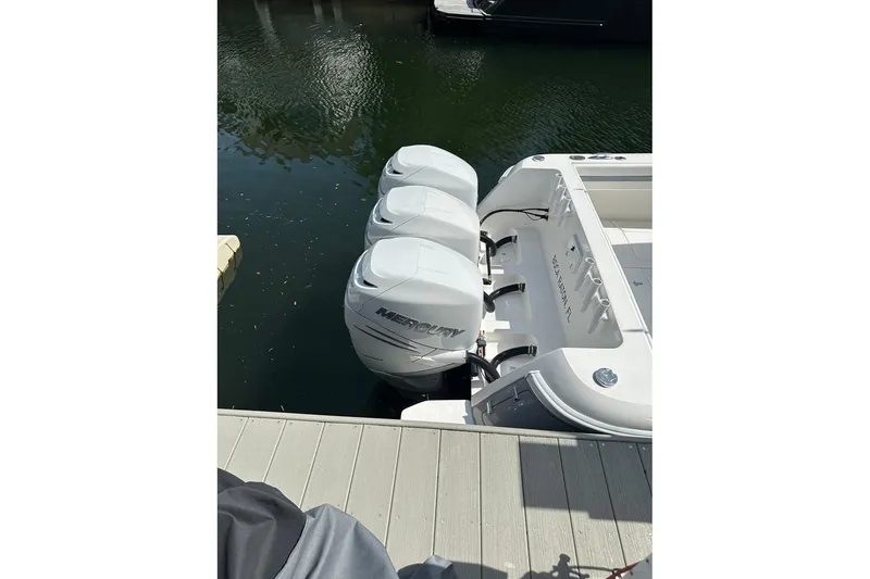 Slide: The Image of 2013 Intrepid 375 Center Console with triple Mercury outboard engines docked by the water. - 30