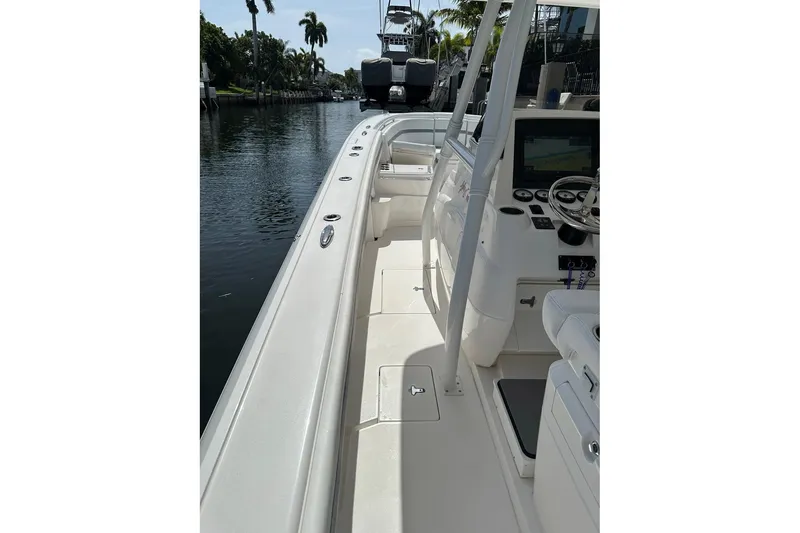 Slide: The Image of 2013 Intrepid 375 Center Console boat interior with helm and seating, docked by a canal. - 13