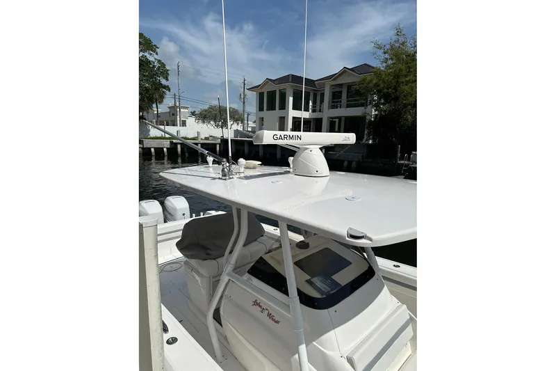 Slide: The Image of 2013 Intrepid 375 Center Console boat with Garmin radar, docked near waterfront homes. - 2