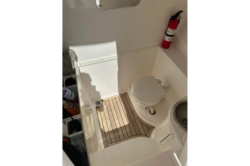 Slide: The Image of 2013 Intrepid 375 Center Console boat bathroom with toilet, sink, and fire extinguisher. - 27