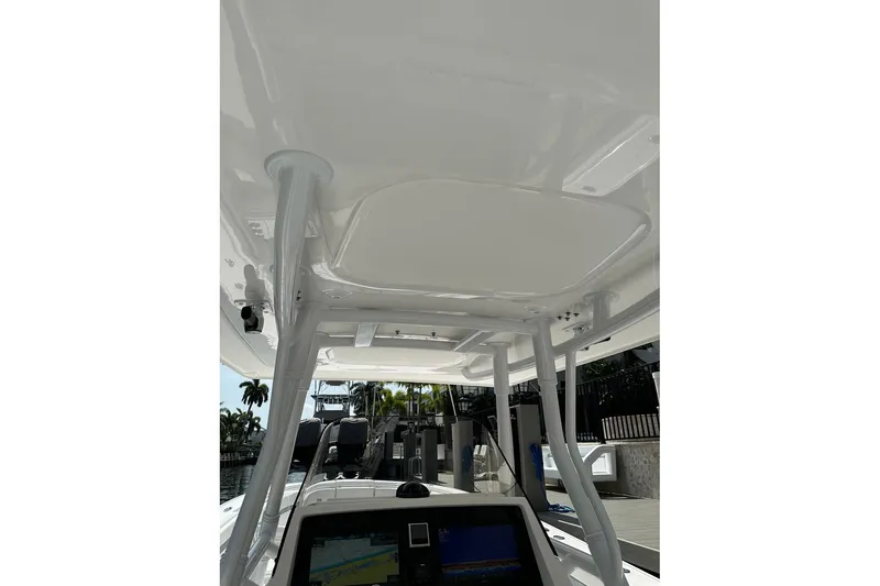 Slide: The Image of 2013 Intrepid 375 Center Console boat interior with navigation display and overhead structure. - 16