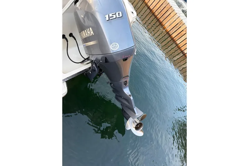 Slide: The Image of Outboard motor on a 2018 Scout 215 XSF boat, docked by wooden pier. - 7