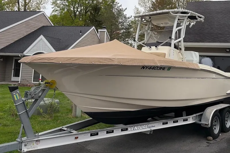 The Image of 2018 Scout 215 XSF boat on trailer, covered, parked in residential driveway. - 0