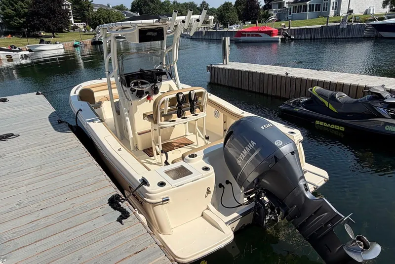 Slide: The Image of 2018 Scout 215 XSF boat docked with Yamaha 150 engine, in a serene marina setting. - 8