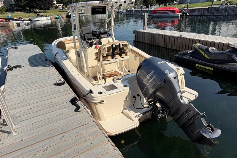 Slide: The Image of 2018 Scout 215 XSF boat docked with Yamaha outboard motor, surrounded by calm water. - 4