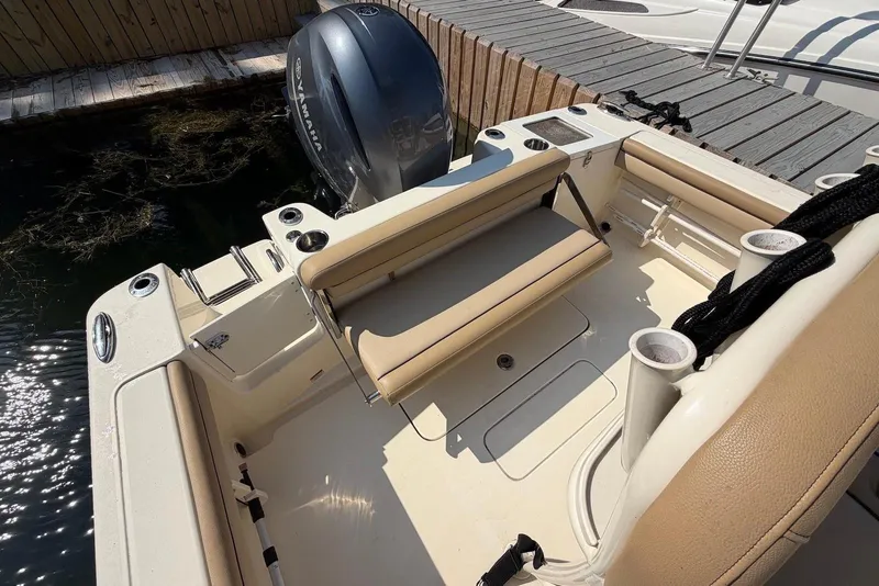 Slide: The Image of The image shows the cockpit of a 2018 Scout 215 XSF boat with beige seating. - 24