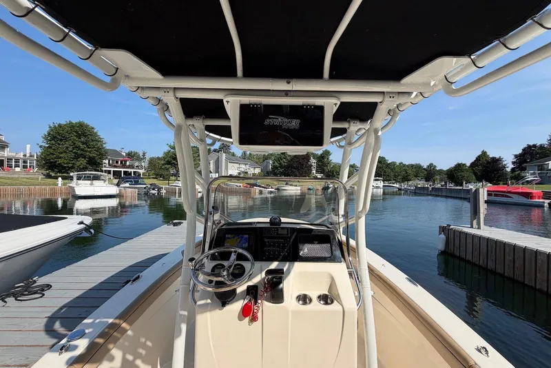 Slide: The Image of 2018 Scout 215 XSF boat docked in a scenic marina setting. - 11