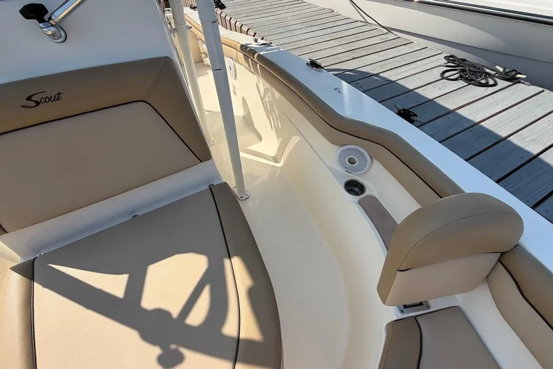 Slide: The Image of 2018 Scout 215 XSF boat interior with beige seating and dockside view. - 19
