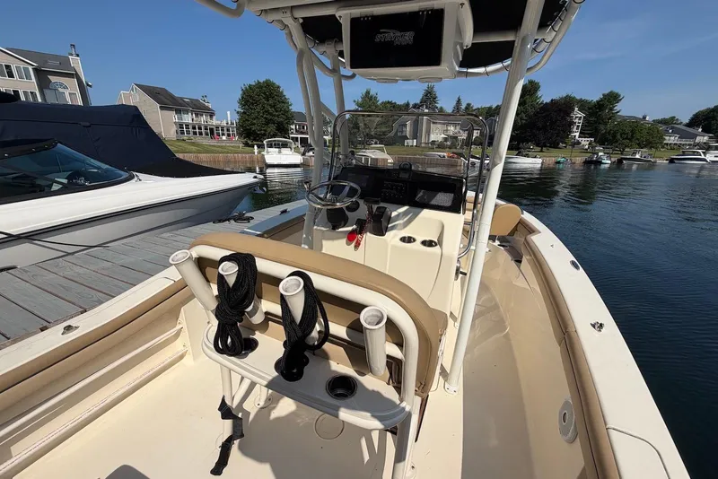 Slide: The Image of 2018 Scout 215 XSF boat interior at a marina, featuring helm and seating. - 22