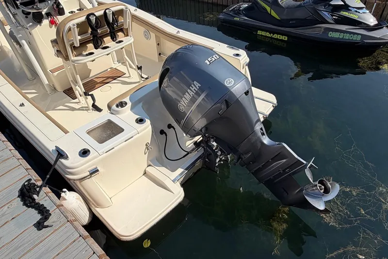 Slide: The Image of 2018 Scout 215 XSF boat with Yamaha 150 outboard motor docked beside a jet ski. - 9