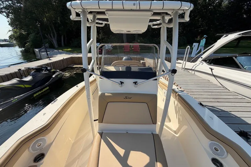 Slide: The Image of 2018 Scout 215 XSF boat docked beside a jet ski and pier. - 17