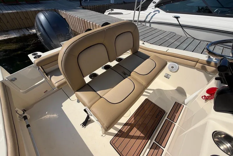 Slide: The Image of 2018 Scout 215 XSF boat interior with tan seating and wooden deck accents. - 23