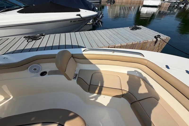 Slide: The Image of 2018 Scout 215 XSF boat interior with tan seating at dock. - 18