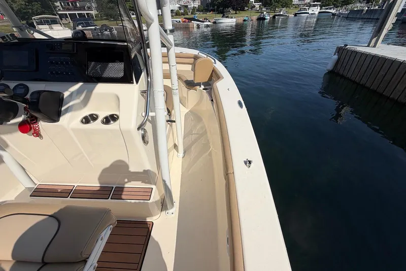 Slide: The Image of 2018 Scout 215 XSF boat docked, showcasing interior and control panel. - 21