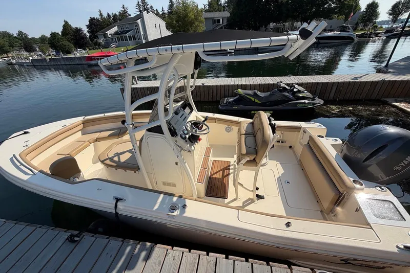 Slide: The Image of 2018 Scout 215 XSF boat docked by a serene waterfront. - 5