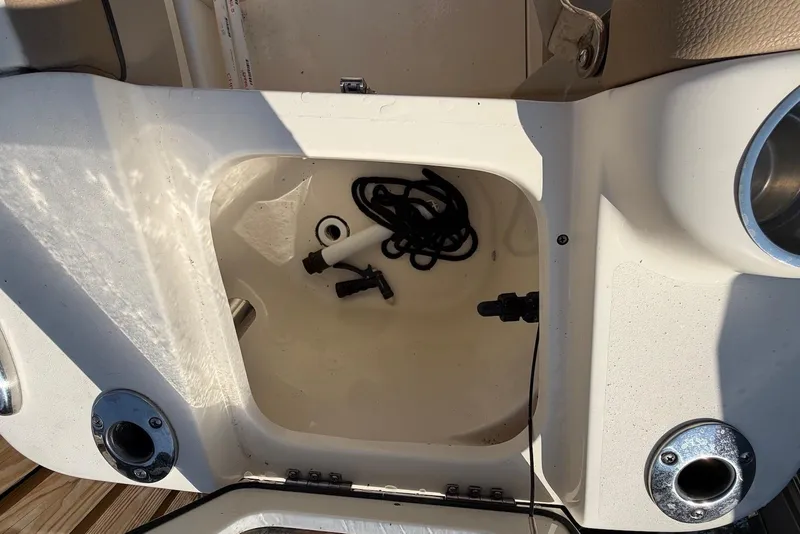 Slide: The Image of Open storage compartment on a 2018 Scout 215 XSF boat with accessories inside. - 30
