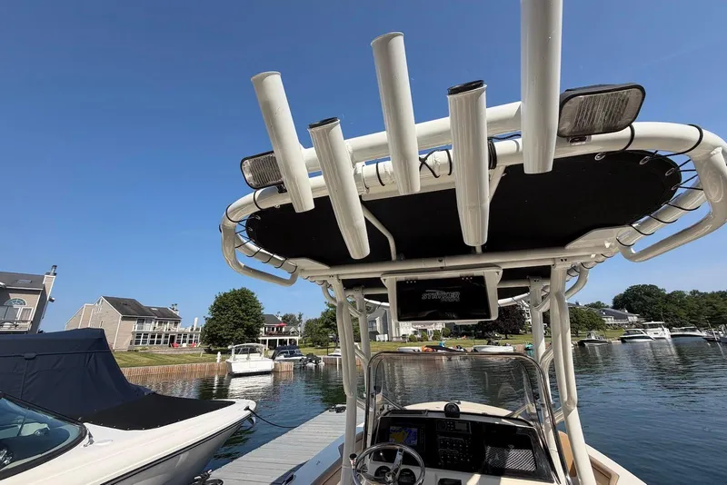 Slide: The Image of 2018 Scout 215 XSF boat docked at a marina under clear blue skies. - 26
