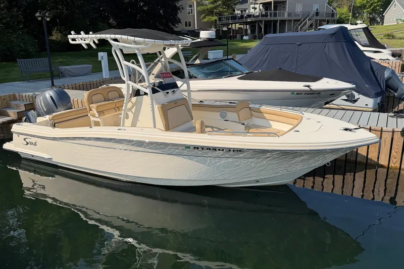 Slide: The Image of 2018 Scout 215 XSF boat docked, featuring sleek design and Yamaha engine. - 2