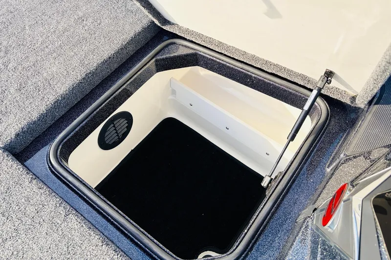 Slide: The Image of Open storage compartment in 2026 Ranger Z521 boat, featuring carpeted interior and hydraulic lift. - 28