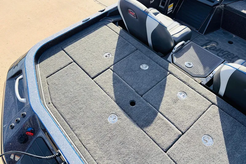 Slide: The Image of 2026 Ranger Z521 boat deck with carpeted storage compartments and seating. - 57
