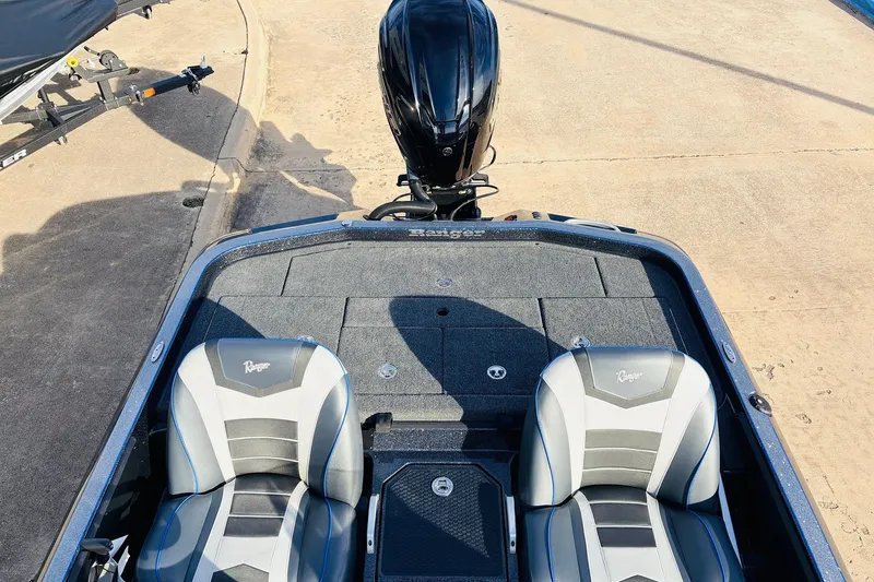 Slide: The Image of 2026 Ranger Z521 boat interior with dual seats and motor, docked on concrete. - 51