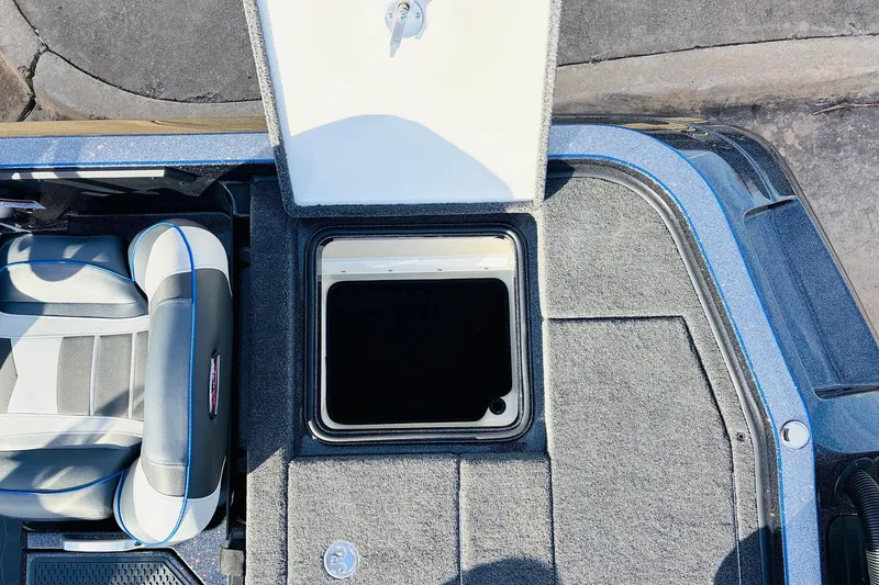 Slide: The Image of 2026 Ranger Z521 boat interior with open storage compartment and cushioned seat. - 62