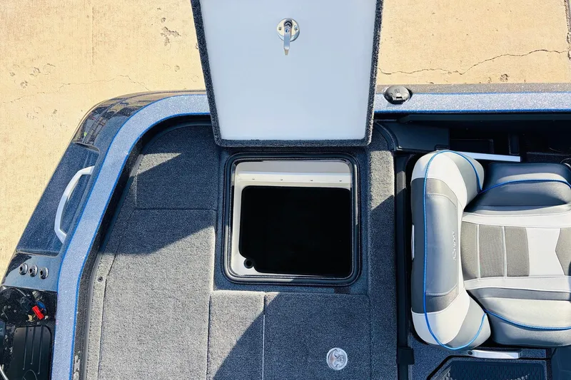 Slide: The Image of 2026 Ranger Z521 boat interior with open storage compartment and cushioned seat. - 59