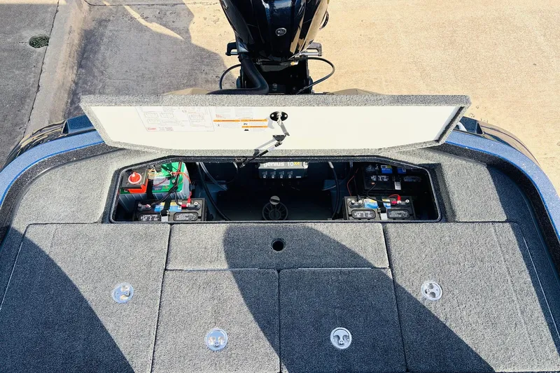 Slide: The Image of 2026 Ranger Z521 boat battery compartment with open hatch, showing multiple batteries and wiring. - 63