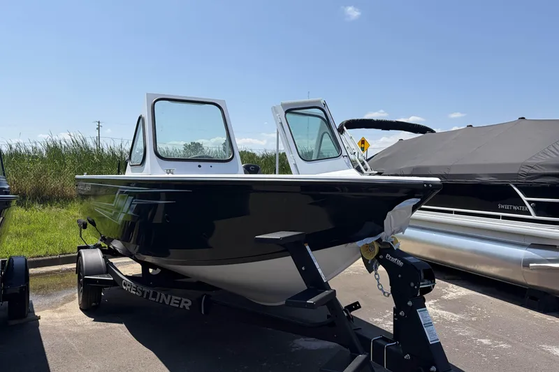 Slide: The Image of 2027 Crestliner 1850 Commander boat on trailer, parked outdoors under clear sky. - 3