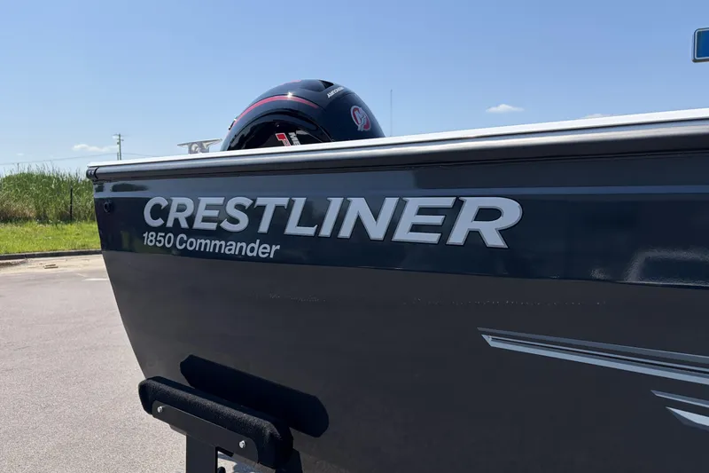Slide: The Image of 2027 Crestliner 1850 Commander boat side view with logo under clear sky. - 18
