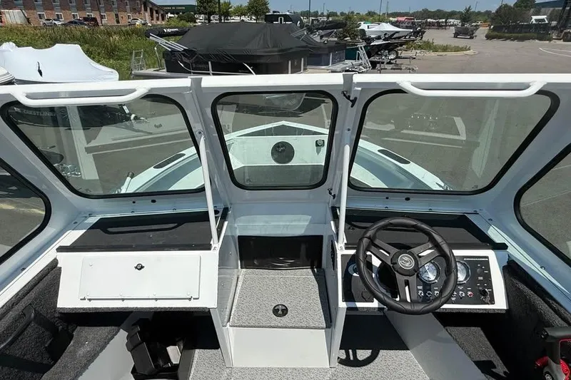 Slide: The Image of 2027 Crestliner 1850 Commander boat cockpit with steering wheel and dashboard controls. - 11