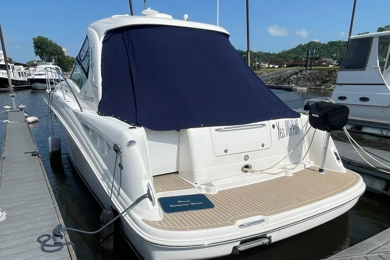 Slide: The Image of 2007 Sea Ray 40 Sundancer docked, rear view with covered cockpit and swim platform. - 2