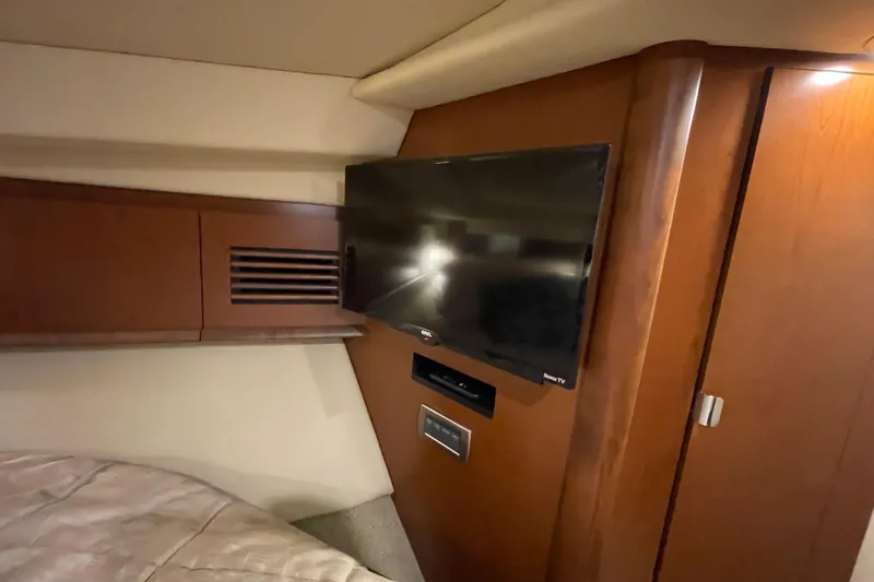 Slide: The Image of Interior of 2007 Sea Ray 40 Sundancer with mounted TV and wooden cabinetry. - 34
