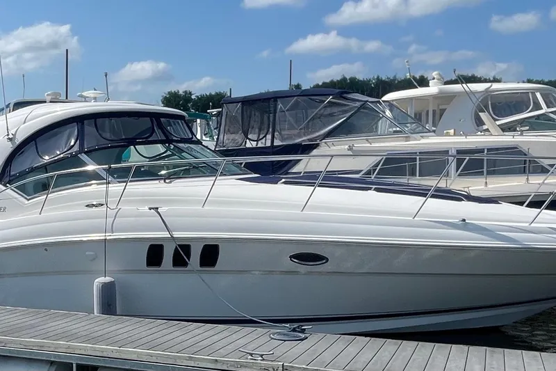 The Image of 2007 Sea Ray 40 Sundancer yacht docked at marina under blue sky. - 0