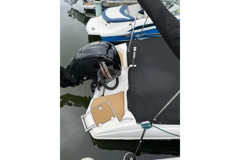 Slide: The Image of 2021 NauticStar 243 DC boat with Mercury outboard motor, docked and covered. - 23